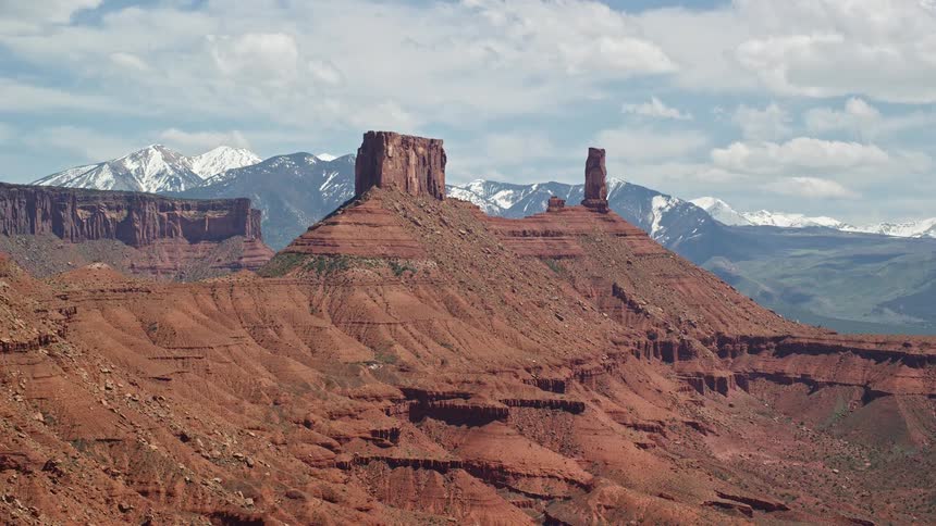  aerial footage of an approach to a desert butte and Castleton Tower in Moab Utah showcasing the arid landscape and natural beauty of the Southwest United States during a sunny day in the summertime