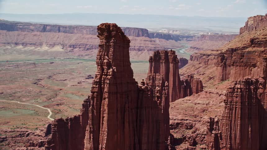 In thisaerial footage enjoy the breathtaking views of The Titan and nearby rock formations at Fisher Towers Utah during a sunny day