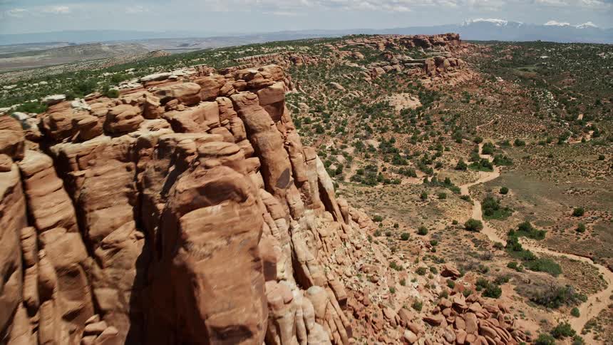  aerial flyby of stunning cliffside rock formations in Eagle Park Arches National Park Utah during a sunny day in summer