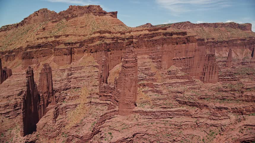 Aerial footage of Utah's iconic rock formations Ancient Art Echo Tower Cottontail Tower and The Titan set against a backdrop of red mountains in the Southwest United States during summer