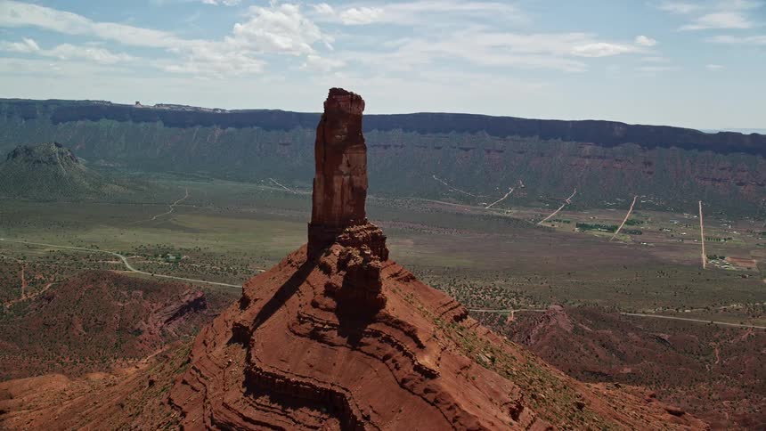 A stunningaerial flyby captures the arid sun-soaked landscape of Utah's southwest as the camera approaches Castleton Tower showcasing the natural beauty of the desert landscape