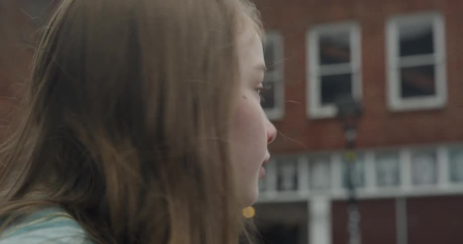 A girl looks both ways by a street