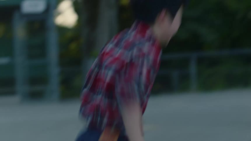 Boy wearing plaid shirt runs outdoors