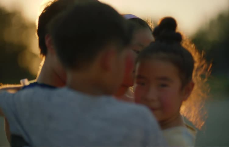 A group of children cuddling each other at sunset