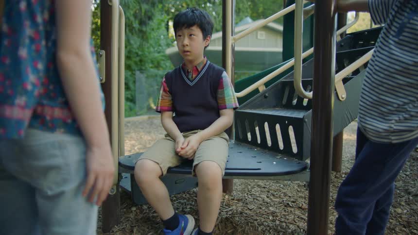 Two kids approach lone boy sitting in playground and intimidate him