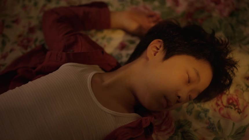 Asian boy wearing white undershirt lays on his back