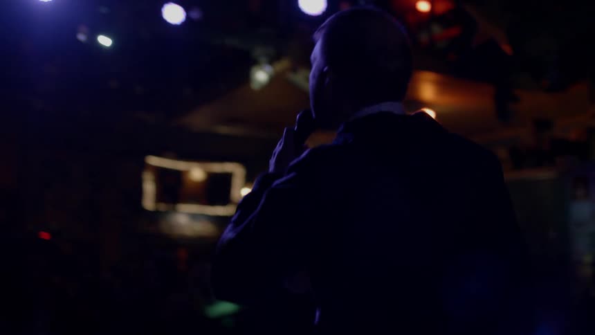 Man sings on stage at night