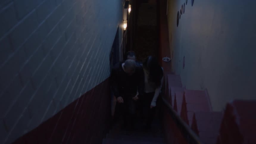 Several people walk up the stairs at night
