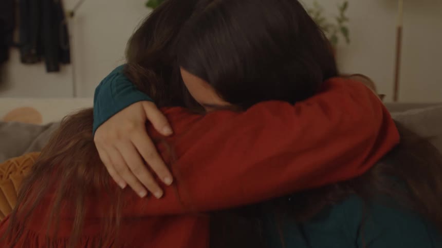 Friends are smiling and hugging each other while crying with happiness