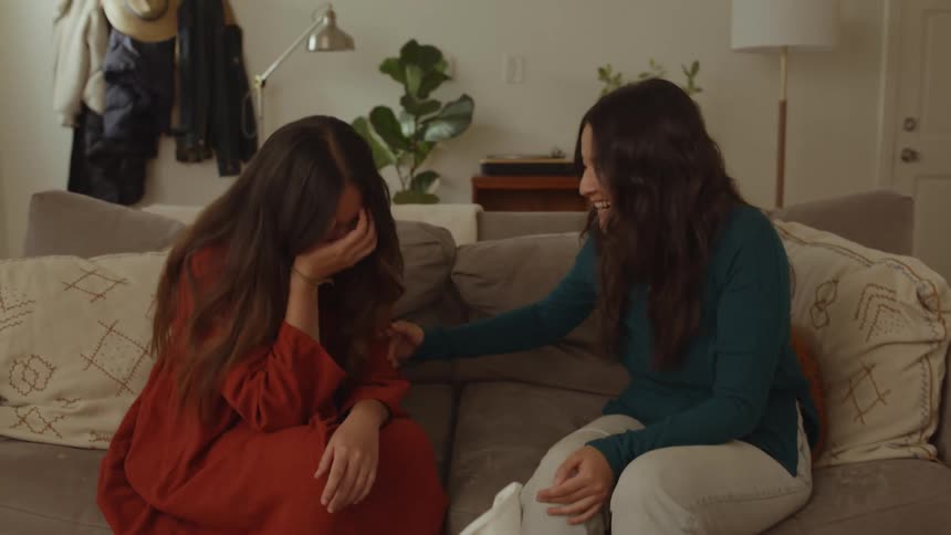 Two women sitting on the couch talking and laughing a lot