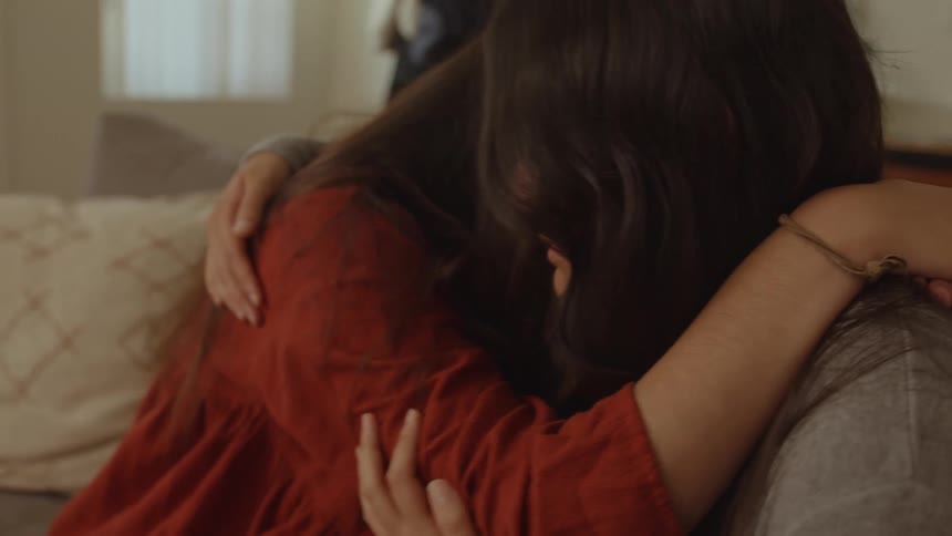 Friends hugging each other while crying on the couch