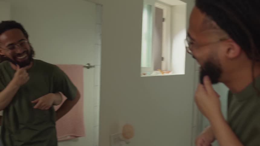 Young couple play with each other in front of a mirror