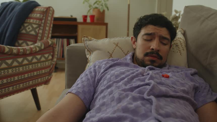 A sleeping man gets food vacuumed off his shirt