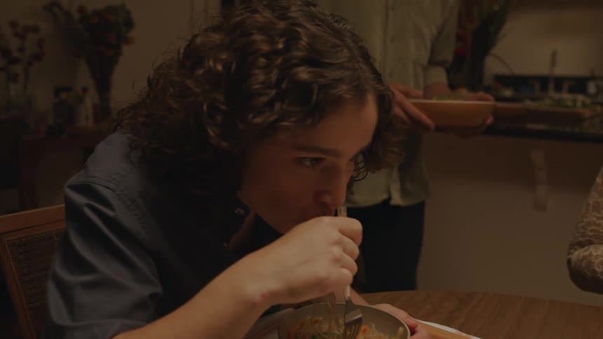 A man is serving two women food as they all look excited and happy about the meal