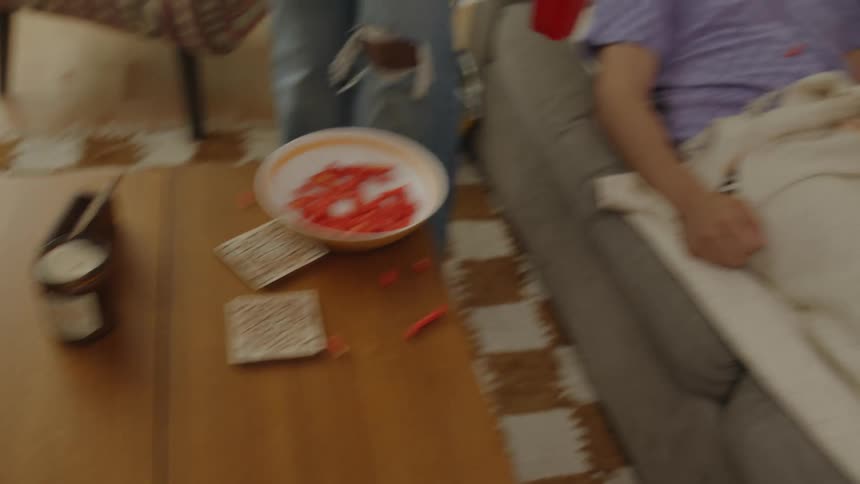 Woman cleaning the house and a man sleeping on the sofa
