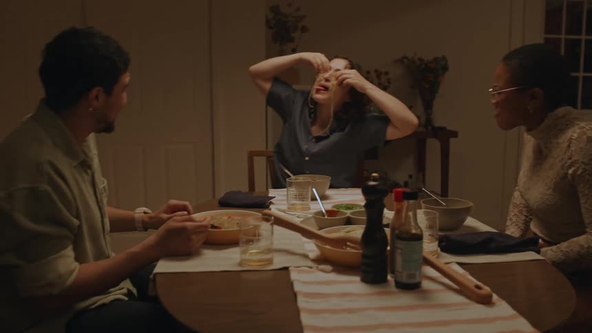 Friends are having dinner while making faces and playing with their food