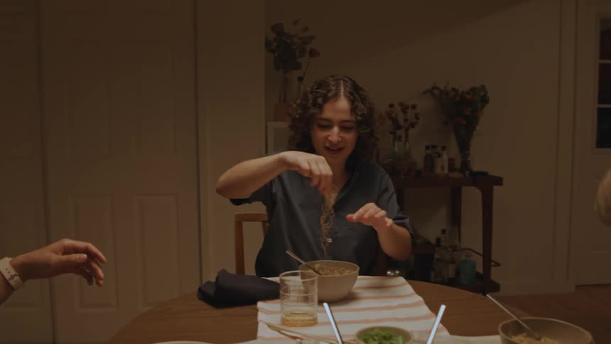 Friends jokingly throw food into their mouths during dinner