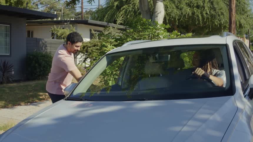 People in a car parked on the street during the day