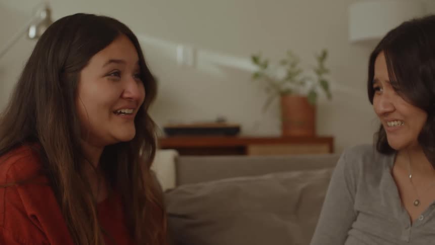 Friends are laughing and talking while sitting on the couch