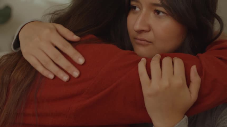 Two women hugging with one of them crying emotionally