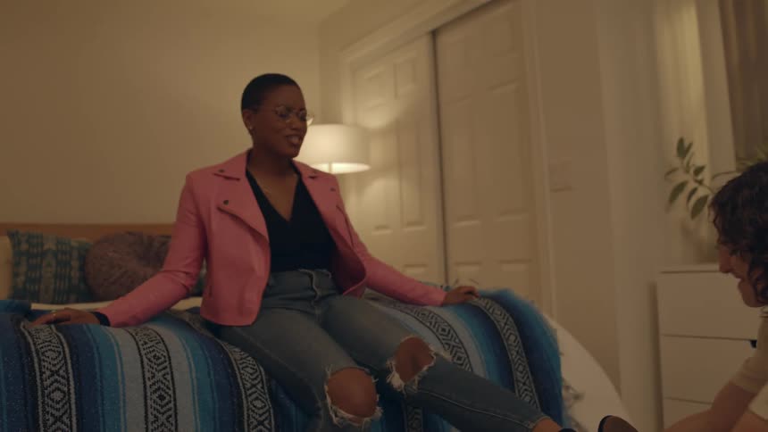Woman pulls her friends black boot in the bedroom