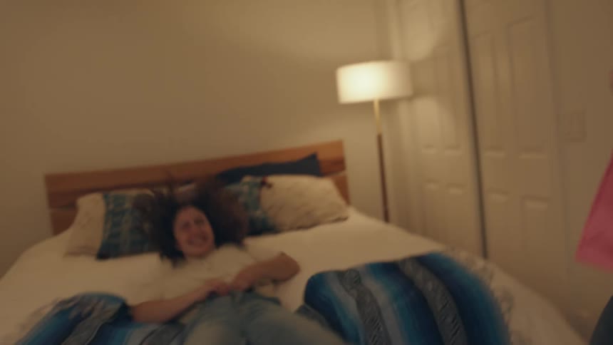 Friends have fun helping each other dress in the bedroom