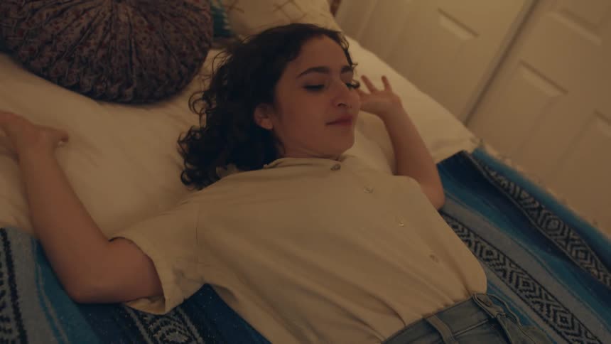 Young energetic woman button her pants on the bedroom