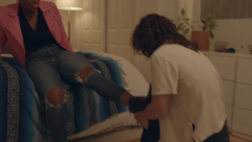 A nervous woman trying to get her boot off her foot