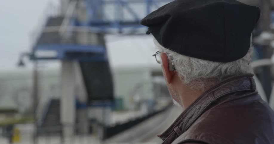 A man looks back and forth near a train station