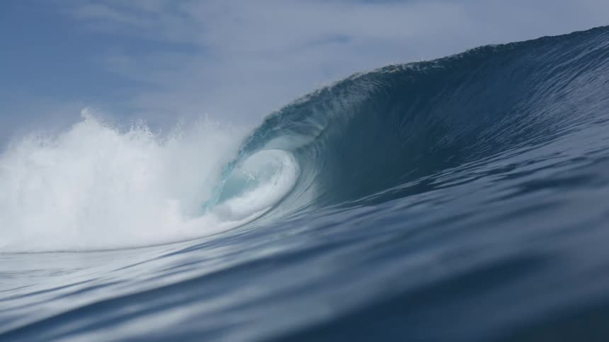 Large ocean wave crests and collapses creating a large amount of white spray