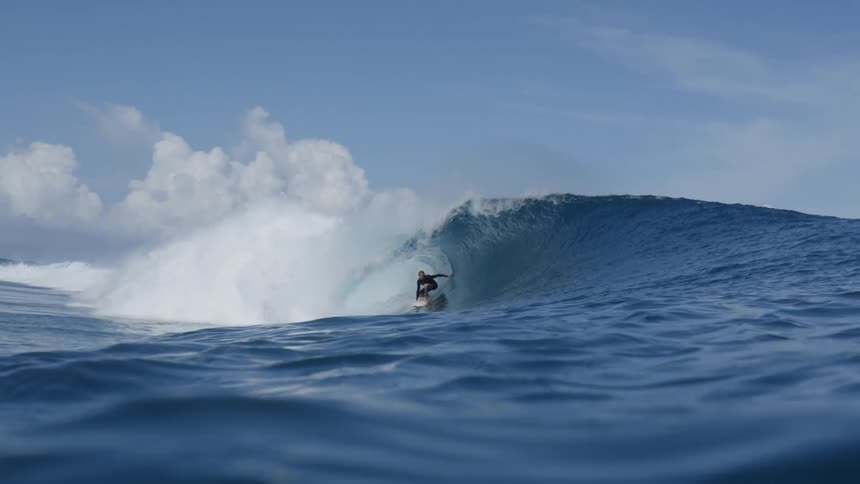 Man surfing on a beach with blue sea