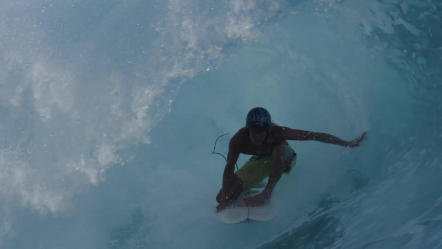 A man is riding a wave on his surfboard