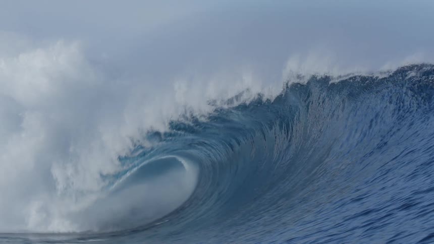 A deep blue ocean wave breaking