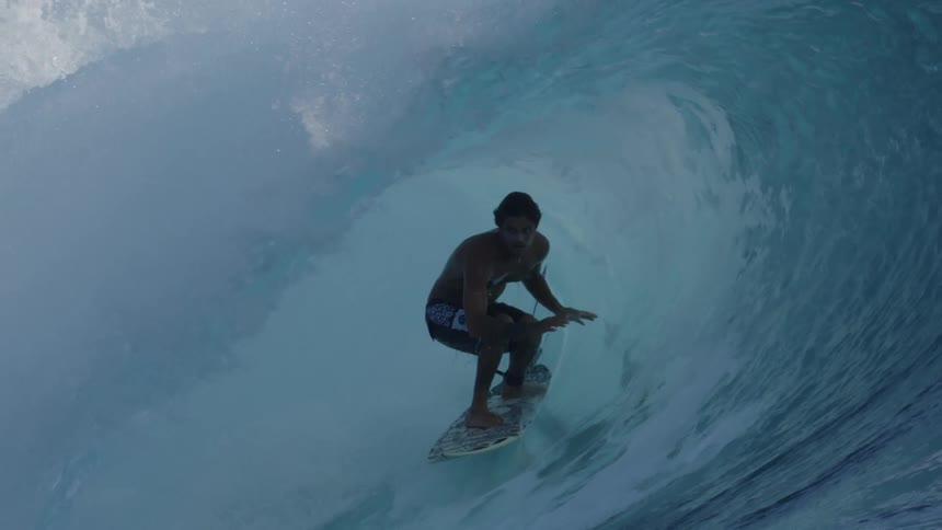 Young surfer riding a beautiful wave inside its barrel