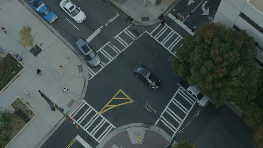 People and cars travel along the intersection below