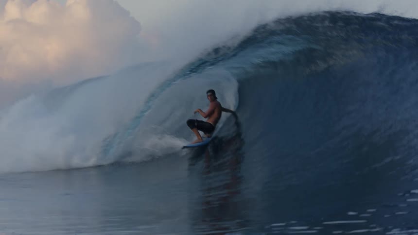 A man is surfing a large wave