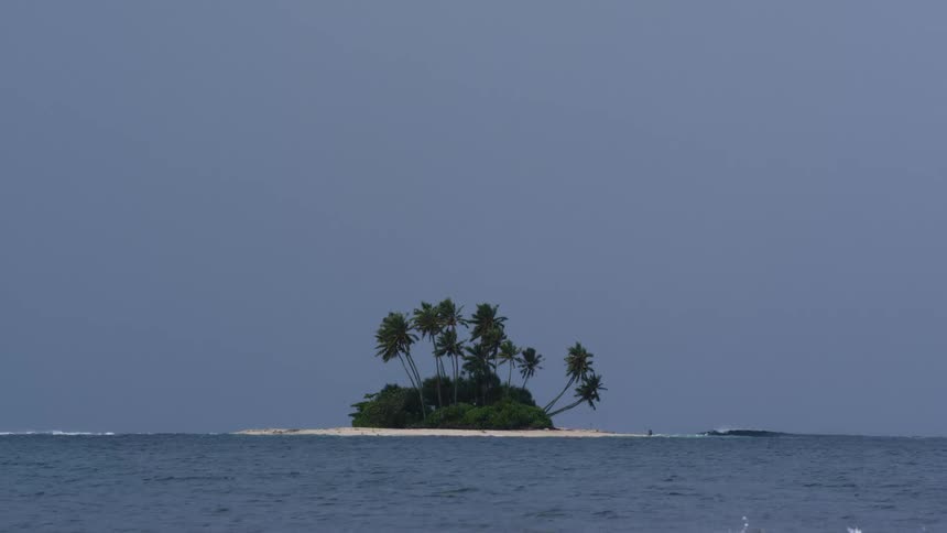 Small island surrounded by a sea with waves