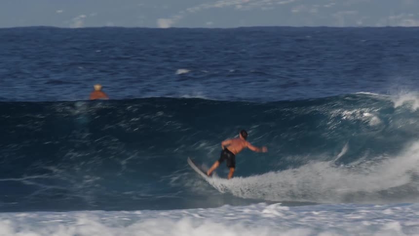 Man rides a wave with a surfboard near the coast