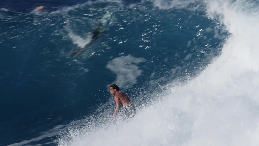 A man doing tricks on a surfboard in the sea