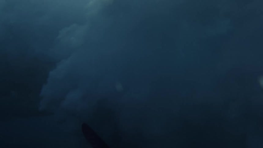 A surfer uses his board to dive under a wave
