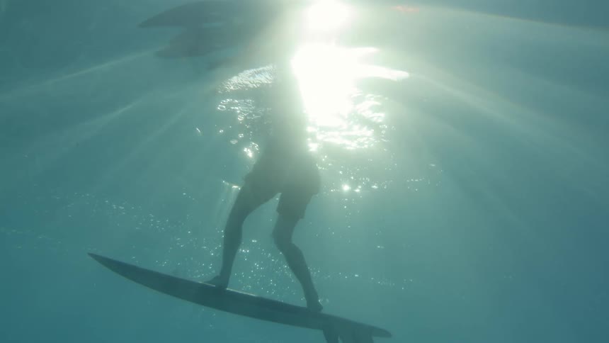 Person performing tricks on a surfboard underwater