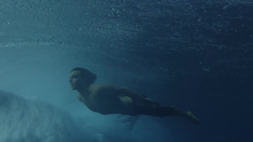 Man swimming underwater on the ocean outdoors during day time