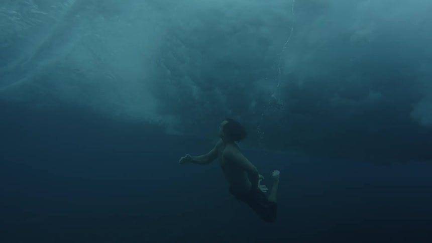 Man wearing shorts swimming underwater in the sea outdoors