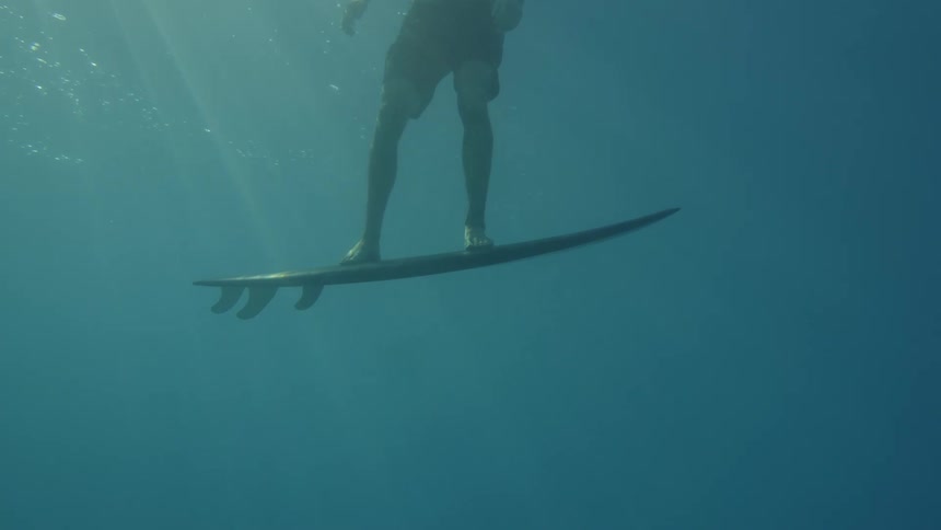 View from inside the sea of a person surfing in the open ocean