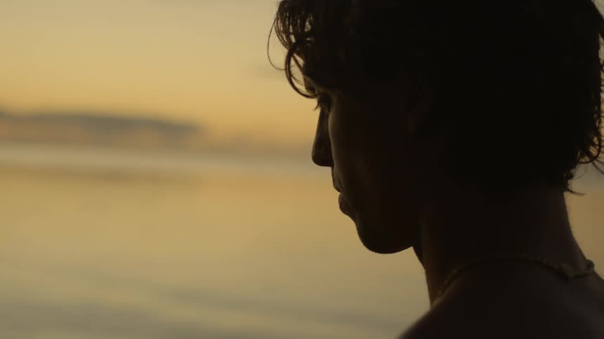A man on the beach watching the sunset