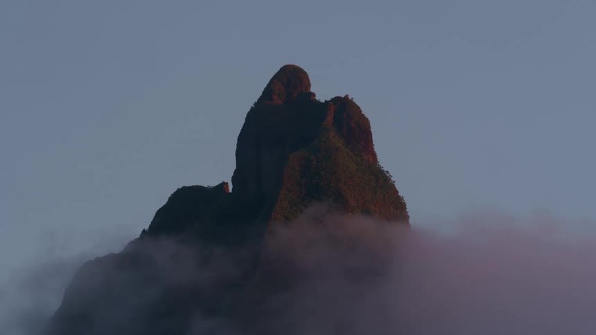 Landscape of a mountain with a peak and cliffs beneath the clouds