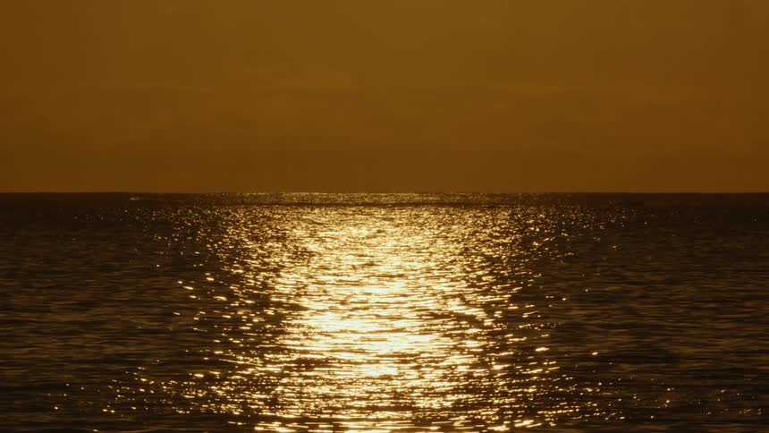 The setting sun reflects on the ocean