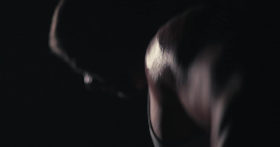 Man working out his arms in a lowlit environment