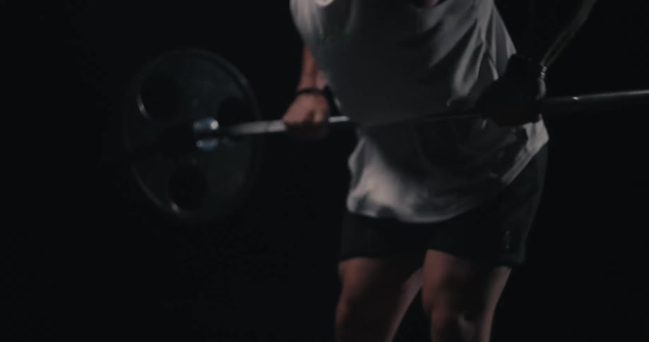A strong person in a white shirt is lifting weights