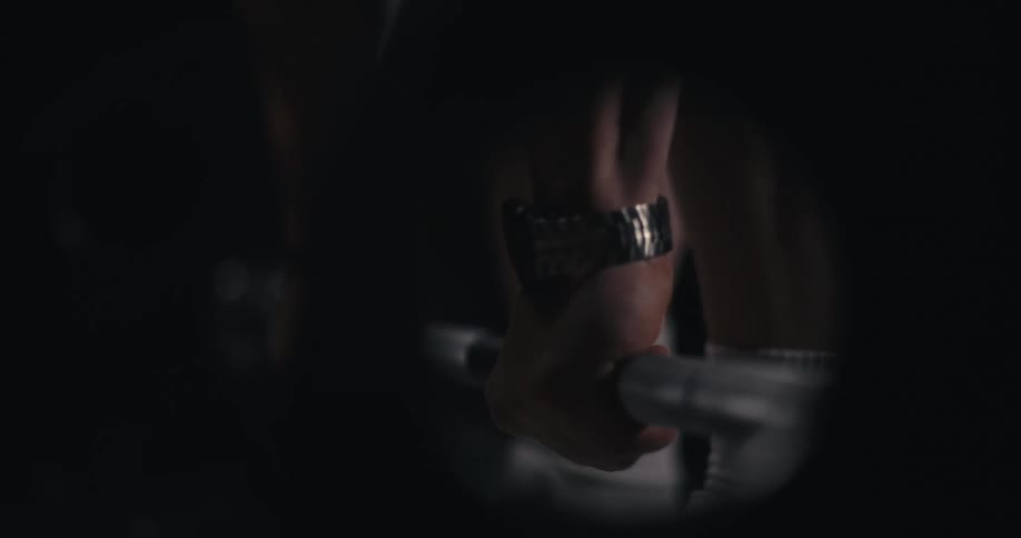 A mans hands grabbing a weight lifting bar and lifting it off the ground